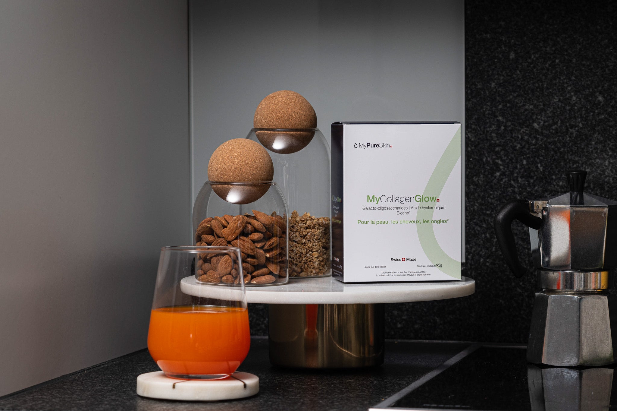 MyCollagenGlow drink placed in kitchen with a glass of MyCollagenGlow drink mixed with juice